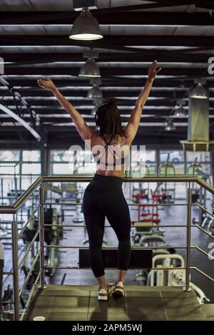 Weibliche Tänze und Stretching, Musikhören im Fitnessstudio, Rückansicht Stockfoto