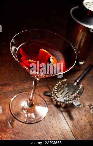 Martini oder Manhattan Drink mit Barutensilien auf Holztisch Stockfoto