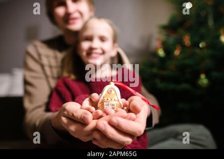 Vater und Tochter zeigen goldenes Weihnachtsornament Stockfoto