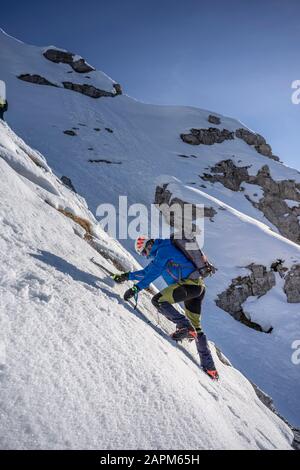 Alpinist, der einen verschneiten Berg aufsteigt, Orobie Alps, Lecco, Italien Stockfoto