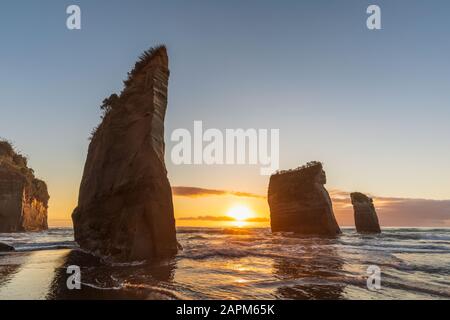 Neuseeland, New Plymouth District, Tongaporutu, Three Sisters Rock Formation bei Sonnenuntergang Stockfoto