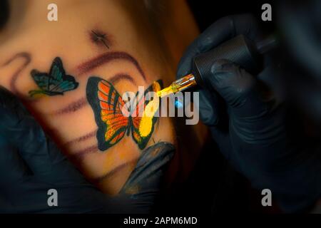 Nahaufnahme von Butterfly Tattoo mit gelber Tinte Stockfoto