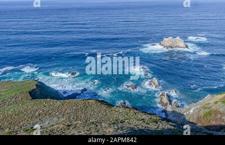 Wellen stürzen in Big Sur, CA auf die Felsen. Stockfoto
