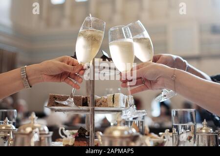 Nachmittagstee High Tea mit Champagner, Kuchen, Sandwiches, Freunden und feinem china; ein fest mit Drinks Freundinnen gutes Essen großartige Atmosphäre Stockfoto