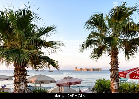 Burg Kizkalesi auf einer kleinen Insel, Schloss Kizkalesi Maiden in der Nähe von Mersin, Türkei, Blick vom Meer mit Palmen Stockfoto