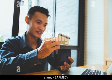 Geschäftsmann mit Kreditkarte und Geldbörse. Zahlung beim Online-Shopping. E-Commerce und modernes Technologiekonzept. Stockfoto