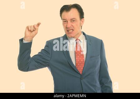 Studio shot reifer Geschäftsmann auf der Suche wütend, während der Zeigefinger Stockfoto