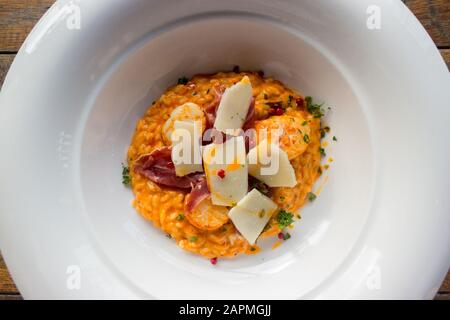 Risotto mit Garnelen in Weiß Platte auf Holz- Hintergrund. Stockfoto
