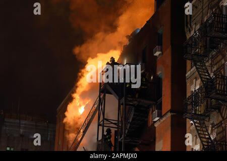 (New York, NY, 23. Januar 2020) 21:00 Uhr. Feuerwehrleute auf einer Feuertreppe und auf dem Dach eines brennenden Gemeindezentrums in der 70 Mulberry St. weitere Informationen finden Sie hier Stockfoto