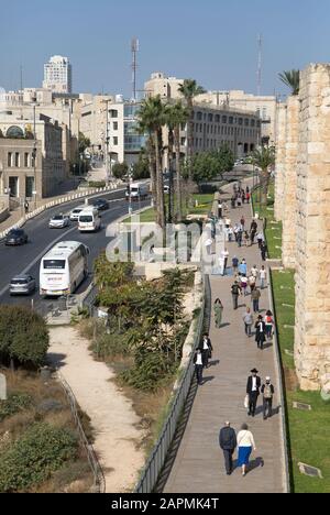 Jerusalem-Straßenszene mit Fußgängern, die im Viertel Mamilla entlang der Außenwand der Altstadt spazieren. Blick von oben. , Israel. Stockfoto