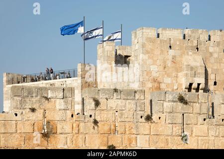 Flaggen des Turms Davids, Israels und des städtischen Jerusalem, die über dem Turm Davids (Zitadelle von Jerusalem) fliegen. Aussichtspunkt, um die Altstadt von Jerusalem zu sehen Stockfoto