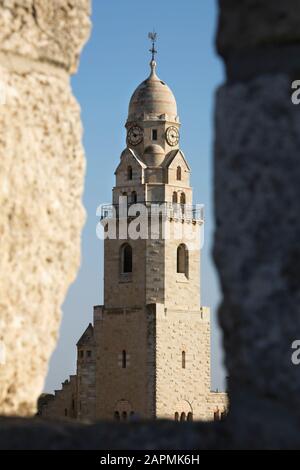 Glockenturm der Dormitionskirche durch eine Lücke in der Stadtmauer rund um die Altstadt von Jerusalem, Israel Stockfoto