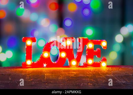 Einrichtung mit "Love Sign Bedroom"-Leuchten mit LED-Marquee Letters in Rot und farbenfrohem Hintergrund. Stockfoto