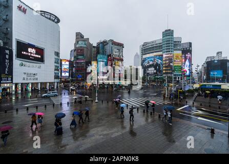 Taipeh, Taiwan - 8. Juni 2019: Verkehr und Menschen, die auf einem Querswalk mit fallendem Regen in Ximending in Taipeh, Taiwan, spazieren gehen. Ximending ist die berühmte Mode Stockfoto