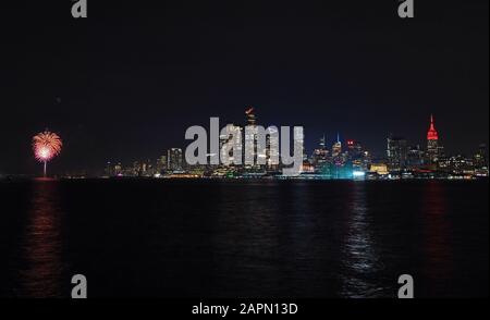 New York, USA. Januar 2020. Die Spitze des Wahrzeichen Empire State Building (R) leuchtet rot für den chinesischen Lunar New Year in New York, den Vereinigten Staaten, 23. Januar 2020. Das Empire State Building wurde am Donnerstagabend in roter Farbe angezündet, um das chinesische Lunar-Neujahr von Rat zu feiern, das am 25. Januar dieses Jahres fällt. Kredit: Li Rui/Xinhua/Alamy Live News Stockfoto