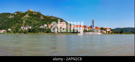 Ausflugsboot auf der Donau vor der Barockkirche Stift Duernstein, hinter den Ruinen von Schloss Duernstein, Wachau, Oberösterreich Stockfoto