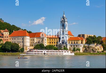 Ausflugsboot auf der Donau vor der Barockkirche des Klosters Duernstein, Duernstein, Wachau, Oberösterreich Stockfoto