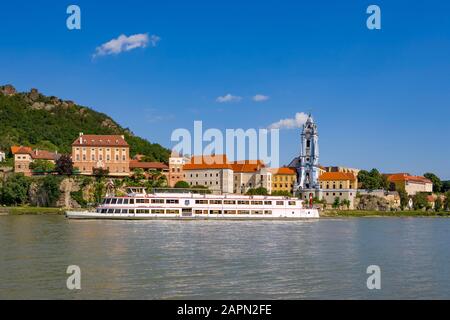 Ausflugsboot auf der Donau vor der Barockkirche des Klosters Duernstein, Duernstein, Wachau, Oberösterreich Stockfoto