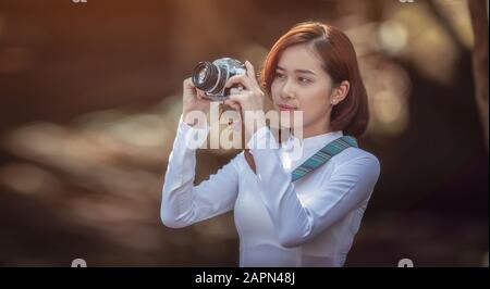 Schöne, junge vietnamesische Straßenfotografin macht ein Foto. Stockfoto