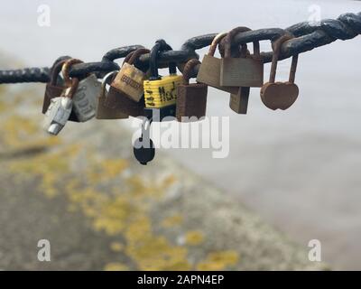 Weitwinkelaufnahme von mehreren Schlössern, die neben jedem hängen Andere aus einer Metallkette Stockfoto