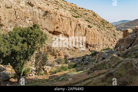 Wanderer auf dem Weg zum alten kloster faran bei einem prälat in wadi qelt am Westufer mit Ruinen einer Kirche und Aquädukt im Vordergrund Stockfoto