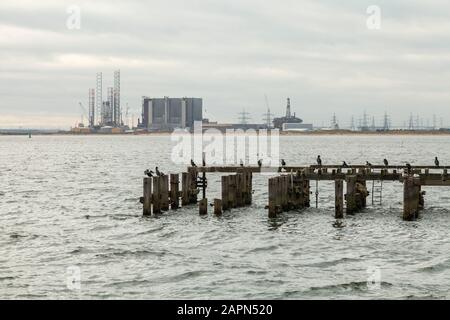 Ein Blick auf South Gare, Redcar an der Tee-Einmündung, der die alte Anlegestelle und die Skyline der Industrie einschließlich des Atomkraftwerks Hartlepool zeigt Stockfoto