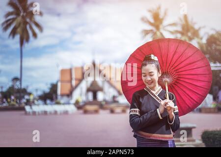 Porträt der Schönen thailändischen Frauen in Lanna Tracht, Handgefertigter Regenschirm, der Vintage-Stil in Thailand macht Stockfoto