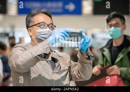 Januar 2020. Kowloon Hong Kong Passagiere am Schnellbahnhof im Bahnhof West Kowloon nach dem Konfirmatin von Coronavirus in Hongkong trägt Dieser Passagier eine Maske und Handschuhe. Stockfoto