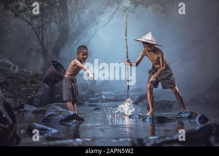 Angeljungen, die im Fluss, auf dem Land Thailands, angeln. Stockfoto