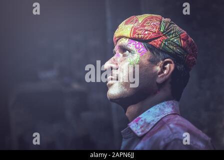 Mathura, INDIEN - Februar 25.2018: Porträt eines indianischen Mannes, das mit Farben auf dem Gesicht verschmiert ist, posiert für ein Foto während der Holi-Festfeier Stockfoto