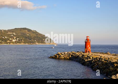 Malerische Aussicht auf die Bucht von Imperia mit dem roten Leuchtturm auf dem Wellenbrecher und dem Capo Berta kap im Hintergrund, Porto Maurizio, Ligurien, Italien Stockfoto