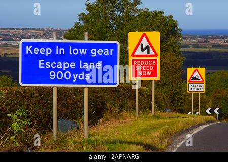 Viele Straßenschilder oben auf dem Staxton Hill, Warnung vor steilem Abstieg, Kurven und Notausfahrt vor yorkshire united Kingdom Stockfoto