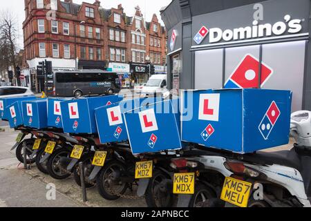 Eine Reihe von Pizza Delivery Rollern außerhalb eines Domino's Fast-Food-Lieferrestaurants, Finchley, London, Großbritannien Stockfoto