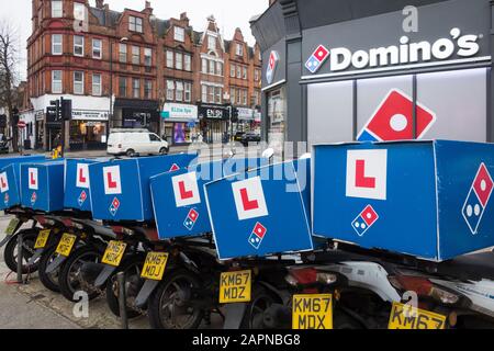 Eine Reihe von Pizza Delivery Rollern außerhalb eines Domino's Fast-Food-Lieferrestaurants, Finchley, London, Großbritannien Stockfoto