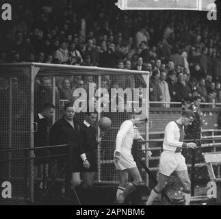 Fußballspiel Ajax gegen GVAV in Amsterdam 5-1; Schiedsrichter, Grenzrichter und die Fußballer Piet Keizer und Klaas Nuninga beim Verlassen des Käfigs Datum: 5. Dezember 1965 Ort: Amsterdam, Noord-Holland Schlagwörter: Grenzrichter, Publikum, Schiedsrichter, Fußball, Fußballer persönlicher Name: Keizer, Piet, Nuninga, Klaas Stockfoto