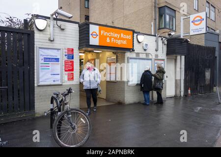 Eine Frau, die von der Einfahrt zum Bahnhof Finchley Road & Frognal, London, Großbritannien, auftaucht Stockfoto