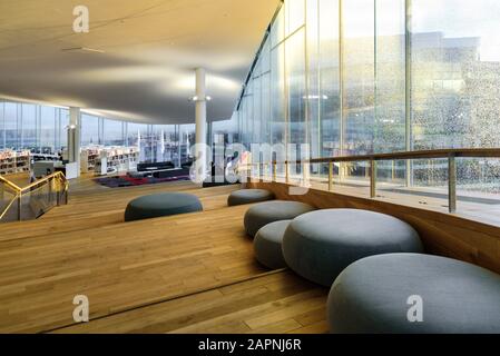 Helsinki, FINNLAND - 28. Dezember 2019: Zentralbibliothek Oodi in Helsinki - moderne Bibliothek. Innenbereich, Leseraum mit vielen Büchern und Stühlen Stockfoto