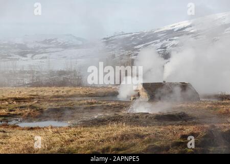 Ein beliebter Halt entlang des Golden Circle ist die hochaktive Geysir Hot Spring Area mit kochenden Schlammgruben, explodierenden Geysiren und atemberaubender Landschaft Stockfoto