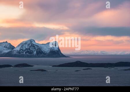 Minimalistische, arktische Landschaft unter farbenfrohem und dramatischem Himmel bei Sonnenuntergang, Skaland, Senja, Norwegen Stockfoto