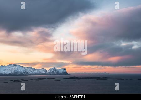 Minimalistische, arktische Landschaft unter farbenfrohem und dramatischem Himmel bei Sonnenuntergang, Skaland, Senja, Norwegen Stockfoto