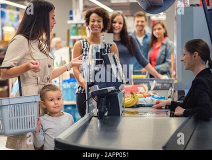 Woamn mit einem Sohn in einem Lebensmittelgeschäft Stockfoto