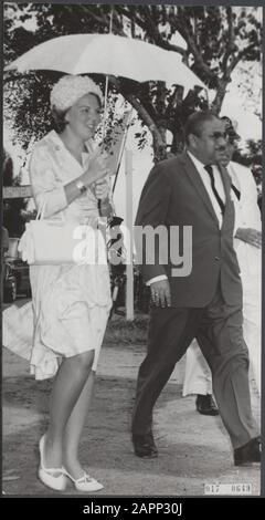 Prinzessin Beatrix in Suriname. Bei der Ankunft in Hanarpolder schützte sich Prinzessin Beatix mit einem Regenschirm vor dem Regen. Sie wird von der Ministerin für Landwirtschaft, Fischerei und Tierhaltung H.S. betreut Radhakishun Datum: 9. März 1965 Ort: Suriname Schlüsselwörter: Besuche, Königshaus, Prinzessinnen persönlicher Name: Beatrix (Prinzessin Niederlande), Radakishun, H.S.M. Stockfoto