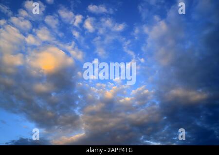 Schöne weiße, orangefarbene Fangeste, ungewöhnliche cumulus, Regenwolken gegen einen blauen Himmel. Malerische, fantastische Wolken. Schlichter Landschaftshintergrund für Sommer, Stockfoto