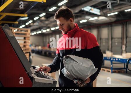 Kurier holt Paket auf einem Lager Stockfoto