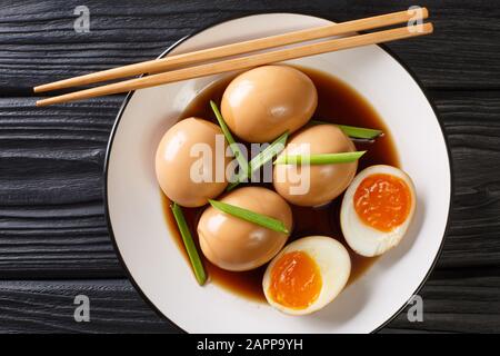 Nitamago ist ein gekochtes Ei in herzhafter Sauce, das in einem Teller auf dem Tisch liegt. Horizontale Draufsicht von oben Stockfoto