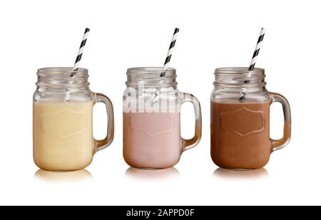 Banane, Erdbeere und Schokolade Milchshakes in Mason Glas Brille, mit Papierstraten, isoliert auf einer weißen Kulisse mit Schlagschatten Stockfoto