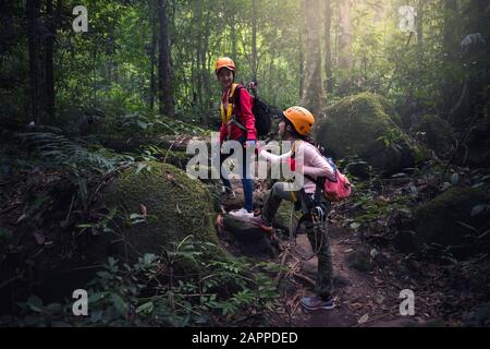 Teamwork-Paar-Wandern helfen sich gegenseitig bei der Vertrauenshilfe Stockfoto