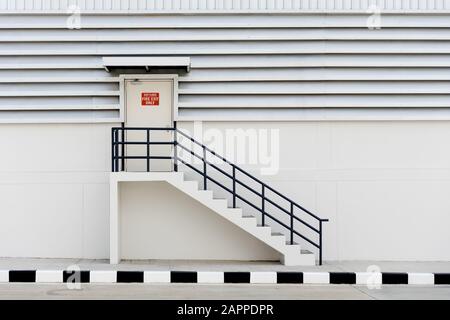 Notausgang für Gebäude mit Ausstiegsschild und Feuerlöscher. Stockfoto