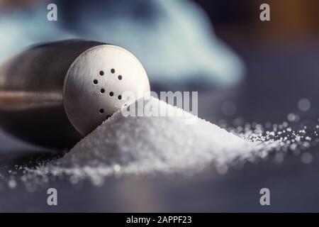 Ausgelaufenes Salz mit stanilem Salzschüttler - Closeup Stockfoto