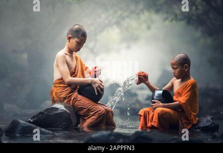 Asiatische Anfängermönche reinigen Almos-Schüssel in Bächen Stockfoto